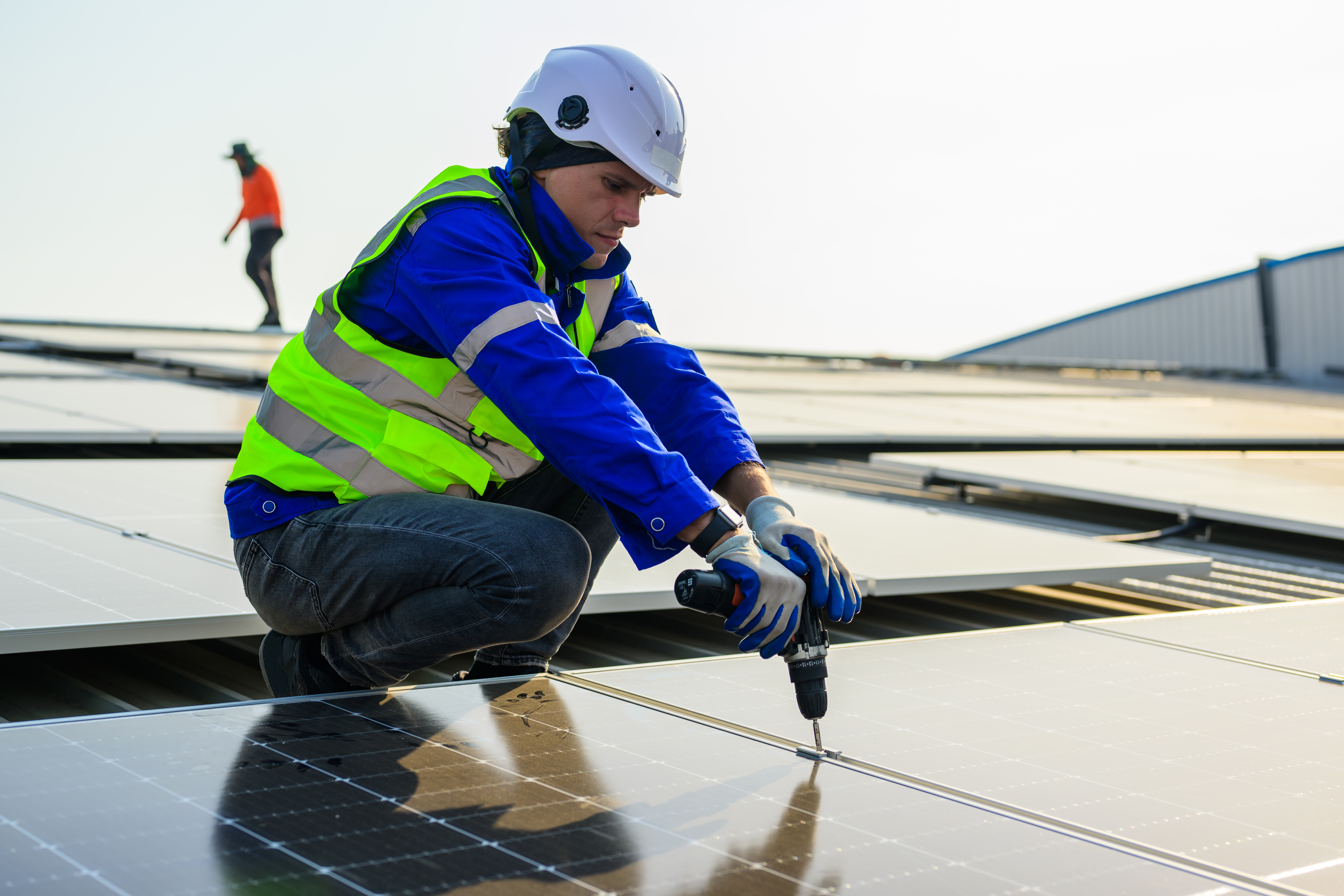 Professional technicians installing solar panels on rooftop Professional technicians installing solar panels on rooftop